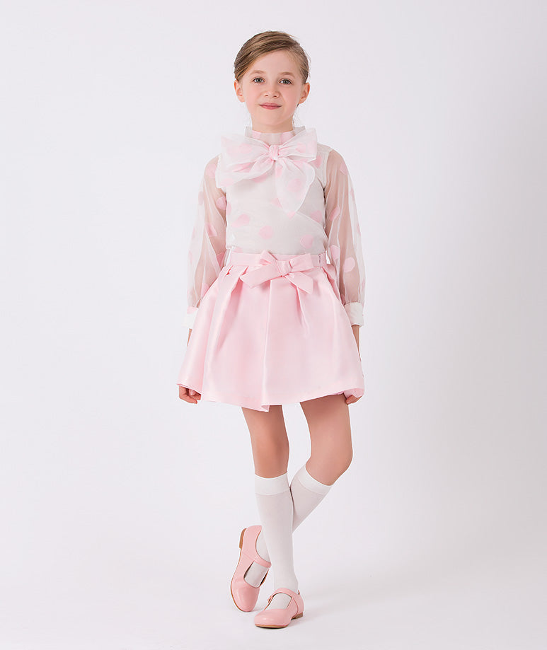 The perfect set of a pink polka dots blouse with a bow and simple elegant pink skirt