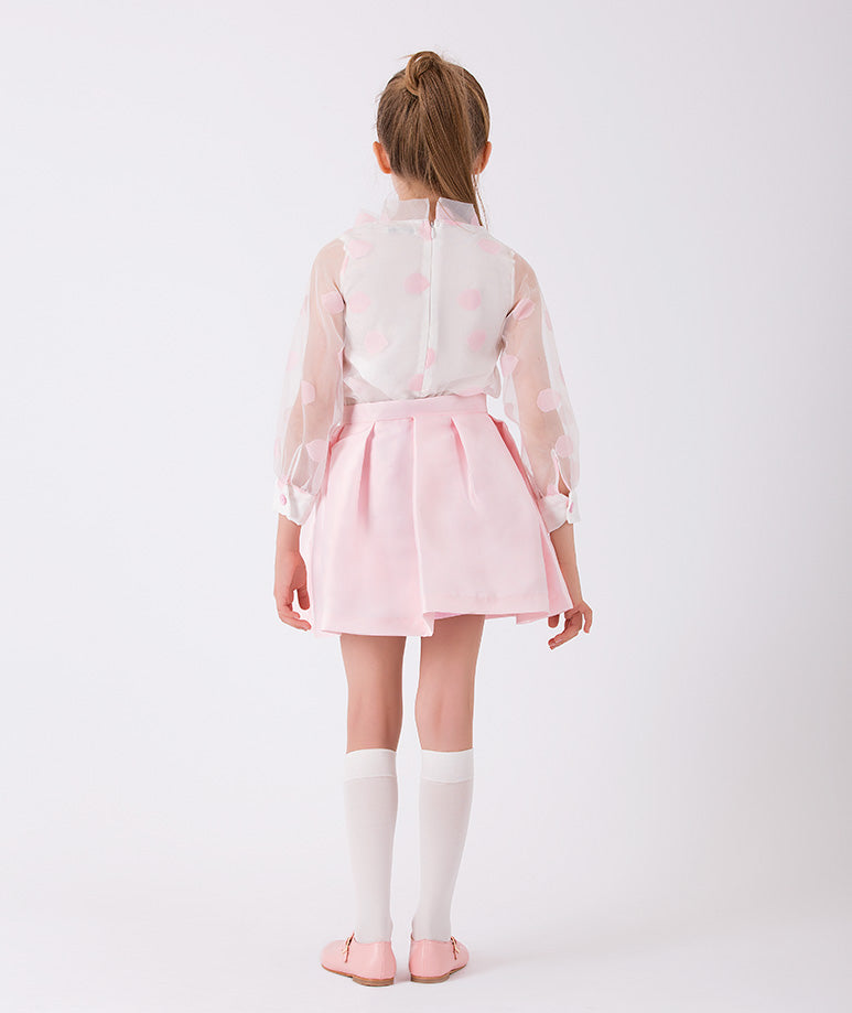an ecru organza blouse with pink polka dots and a matching pink skirt