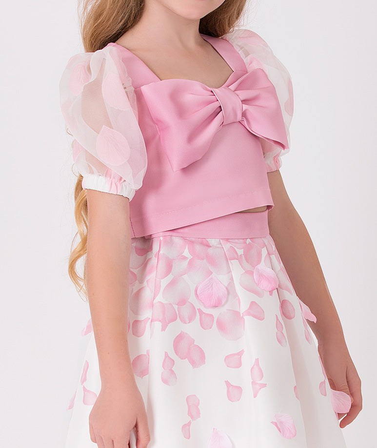 pink blouse with organza balloon sleeves and a big bow on it with a matching skirt that has pink 3D rose petals