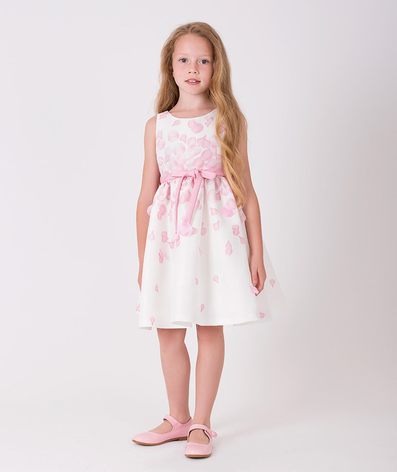 Ecru dress for girls by Mama Luma with pink 3D rose petal prints and a cute little bow on the waist